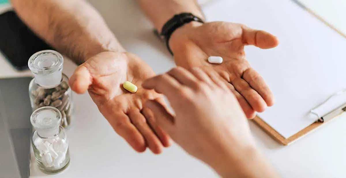 two hands holding pills